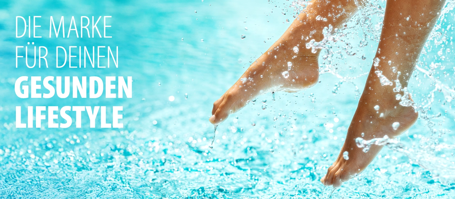 Barfuße Füße einer Person, die über Wasser hängen und Spritzer verursachen.